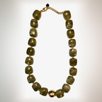 Necklace with green beads and gold chain on a white background